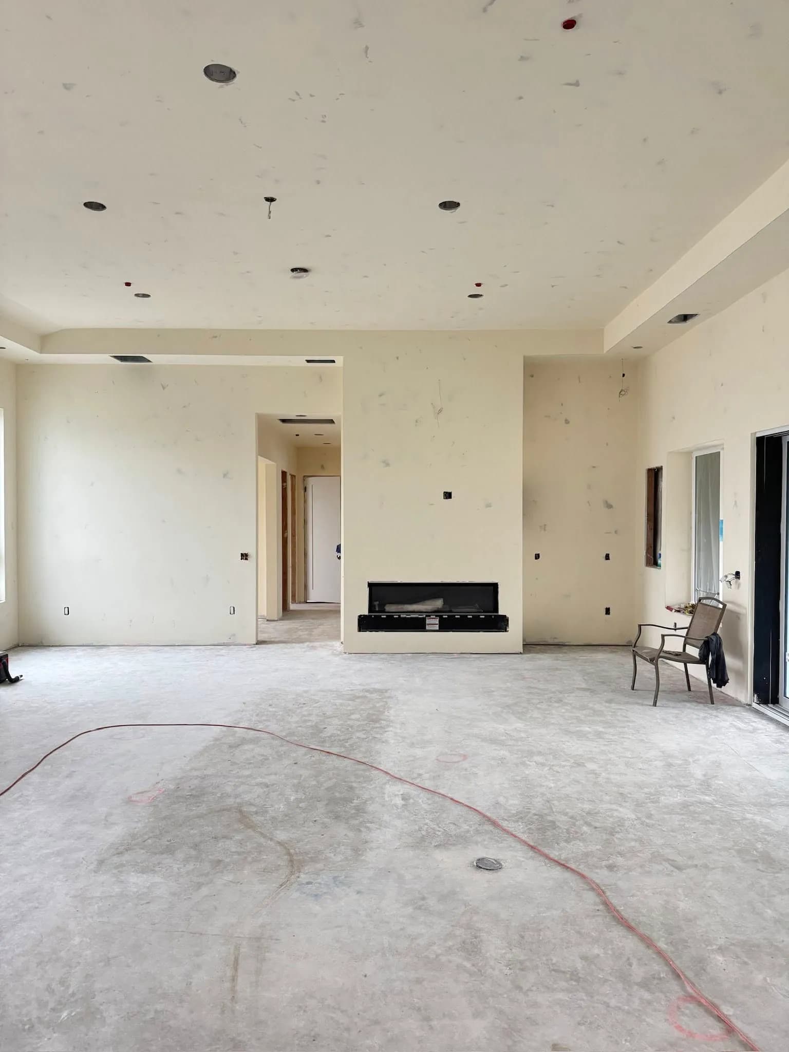 Finished custom-home great room with fireplace by Fuentes Drywall