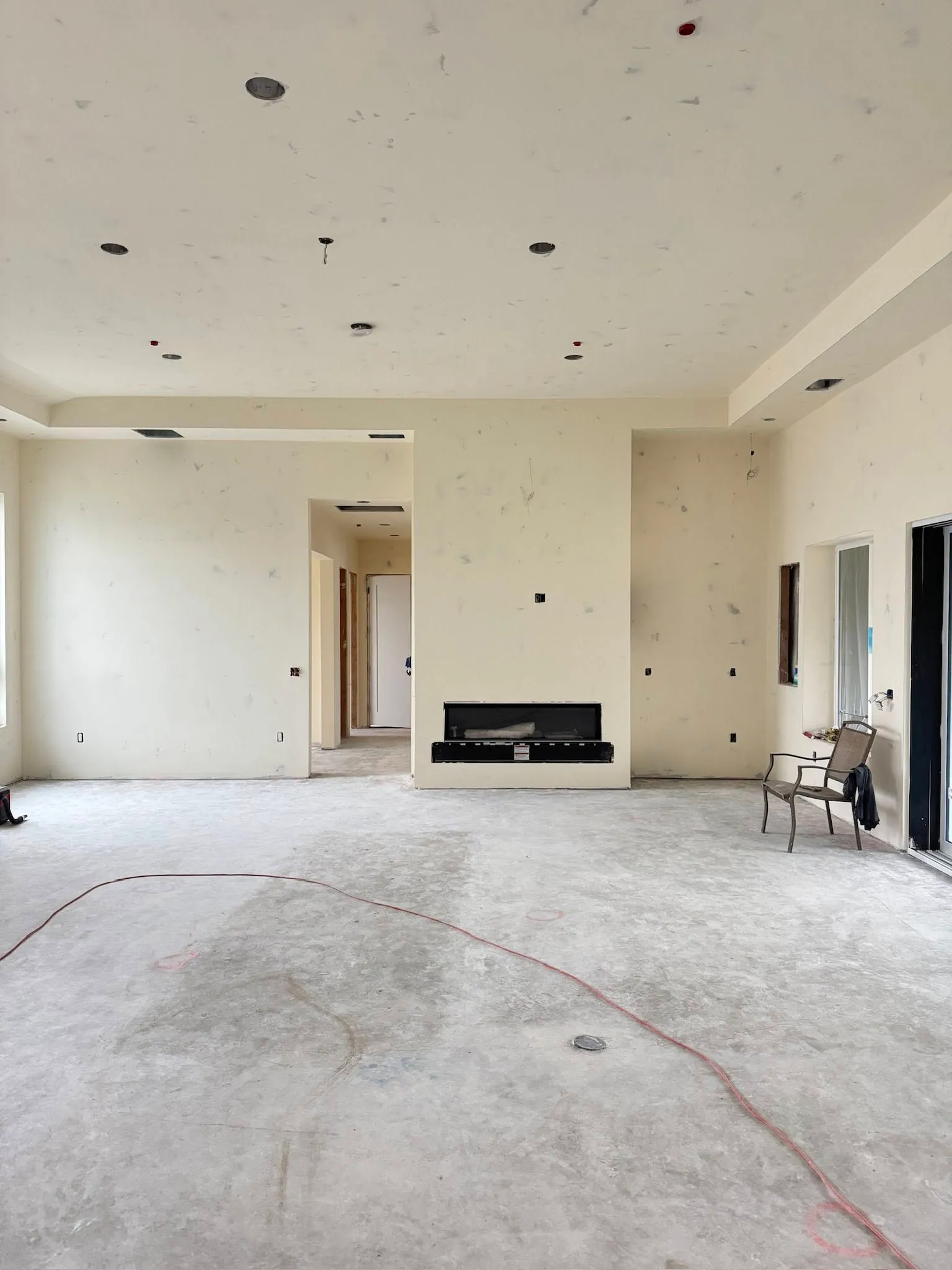 Finished custom-home great room with fireplace by Fuentes Drywall